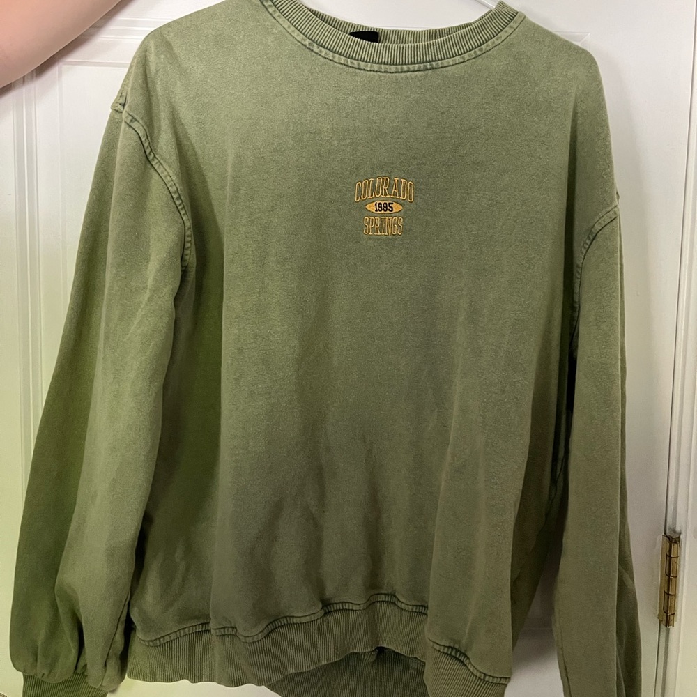Green Urban Outfitters pull over sweatshirt with yellow writing in the center.